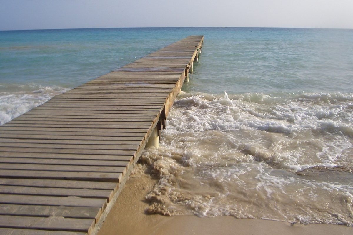 Muelle de madera sobre el mar turquesa de Bayahibe en un día despejado